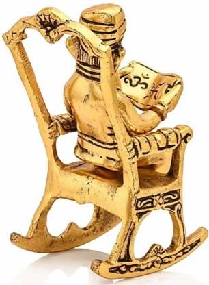 HomeSutra Golden Lord Ganesha Statue Sitting On A Rocking Chair And Reading Ramayan Showpiece